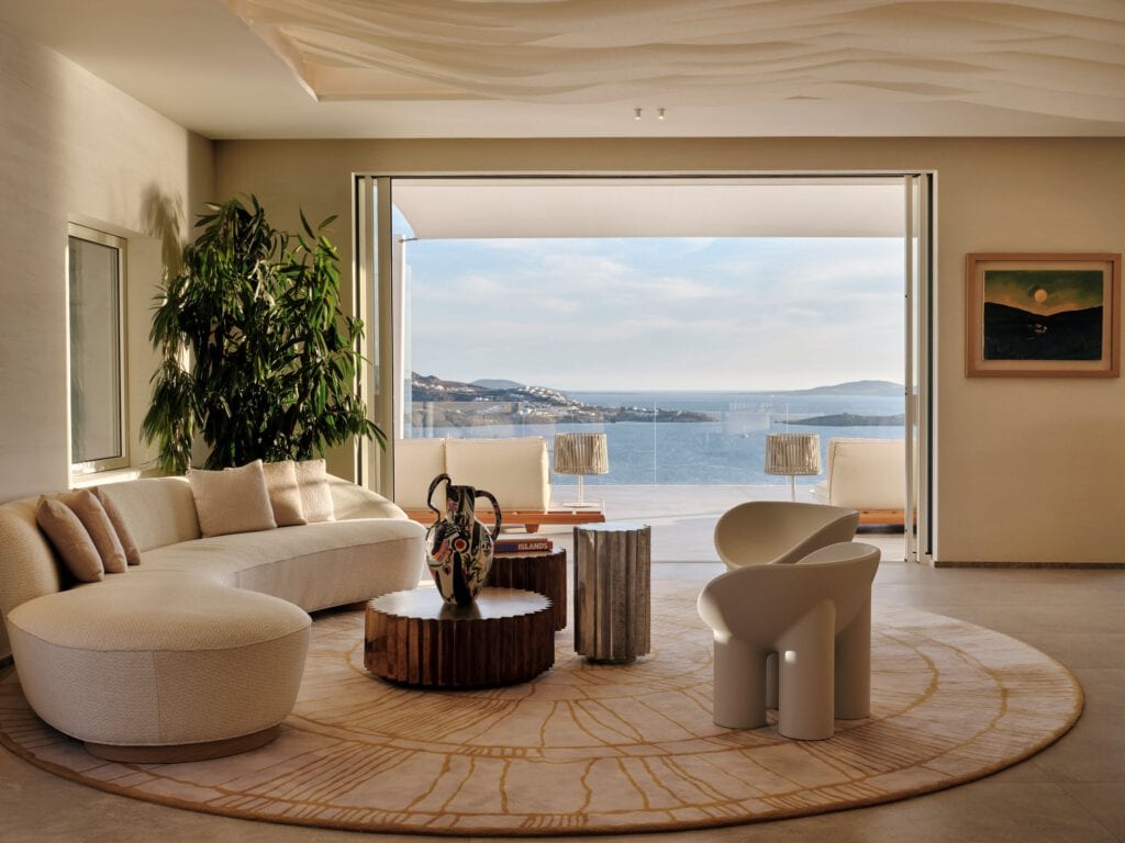 Luxuswohnzimmer mit Blick auf das Meer, moderne Möbel, große Fenster, Pflanzen, Kunstwerke, entspann.