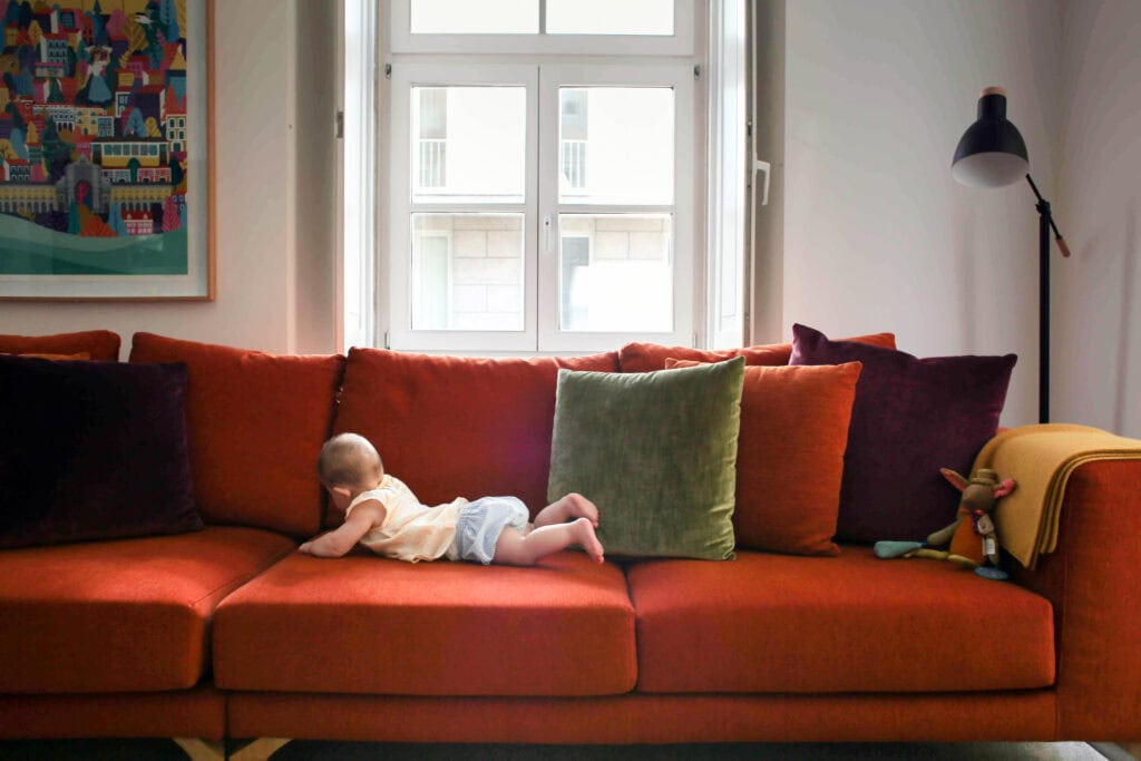 Martinhal Chiado – Baby auf rostfarbener Couch im Familienhotel, Luxushotel Lissabon