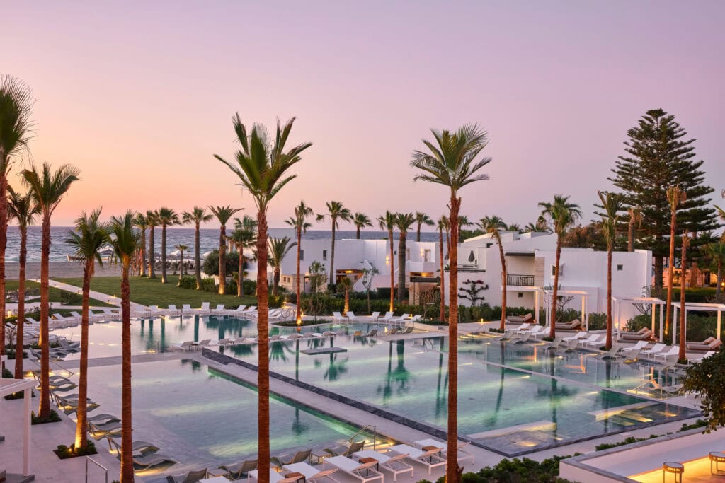 Creta Palace – Poollandschaft mit Palmen bei Sonnenuntergang, Luxusresort Kreta
