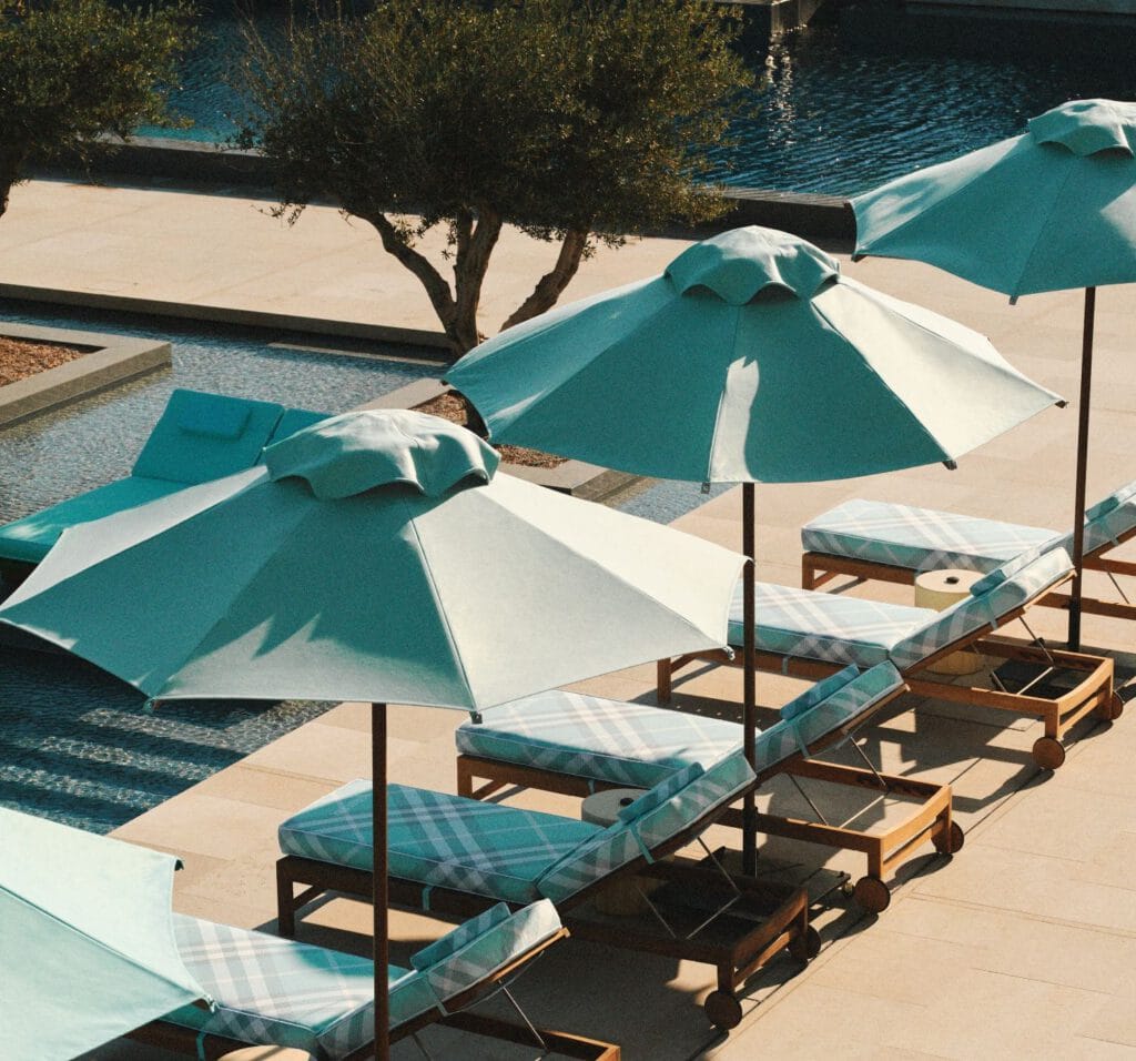 One&Only Aesthesis – Poolbereich mit türkisen Sonnenschirmen und Liegen, Luxusresort Griechenland