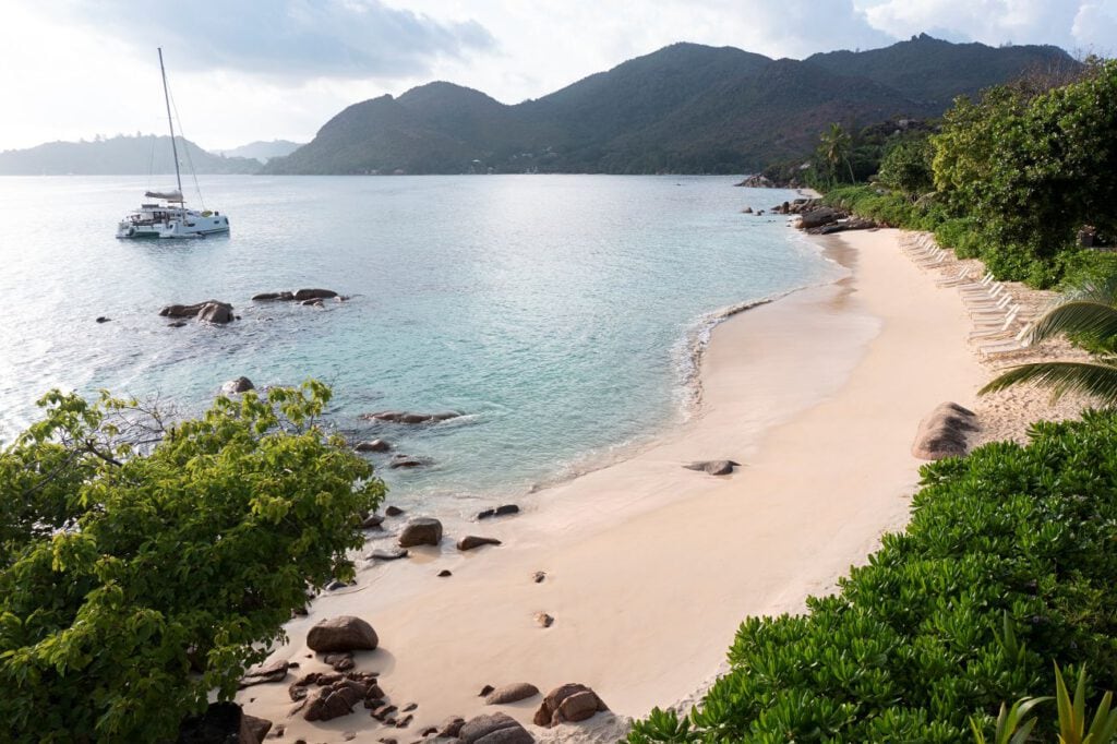 Tropische Bucht mit Sandstrand, Granitfelsen und Katamaran, Luxusresort Seychellen