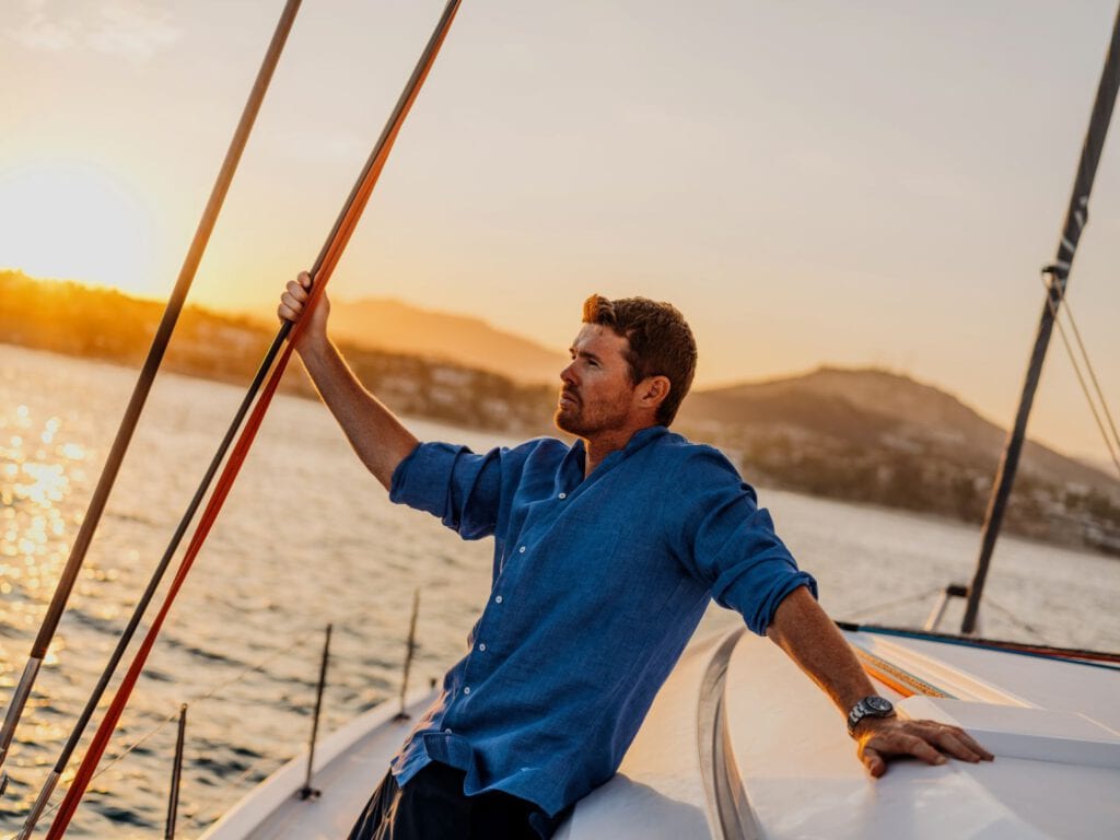 Mann auf Segelyacht bei Sonnenuntergang, One&Only Sease Erlebnis, Luxusresort Aktivitäten