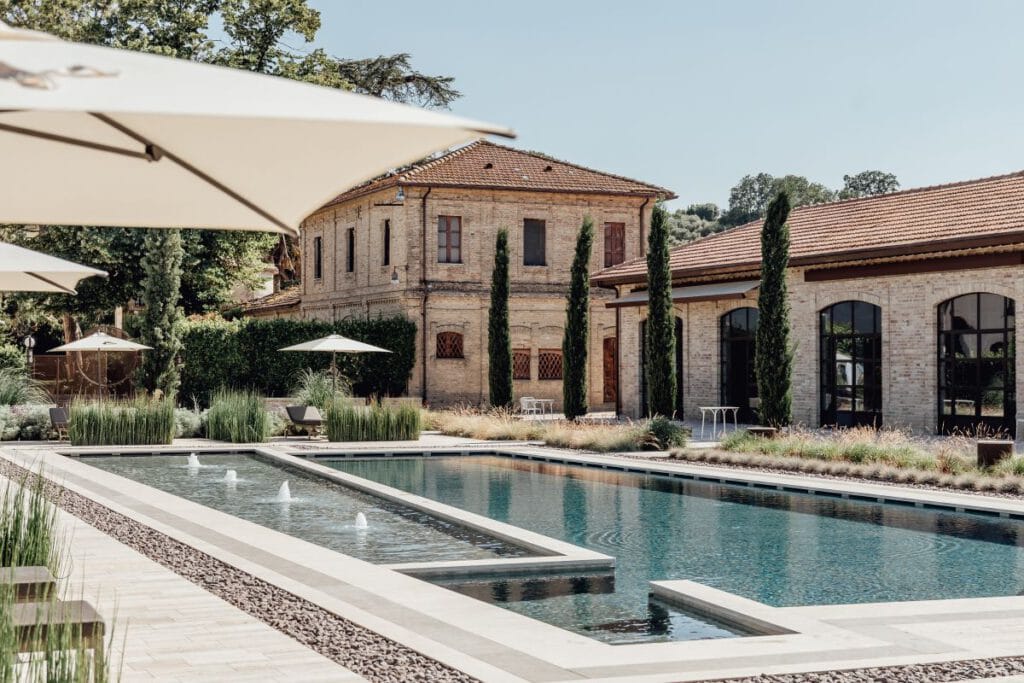 Villa Corallo – Außenpool mit Fontänen und Zypressen vor historischem Herrenhaus, Luxushotel Italien